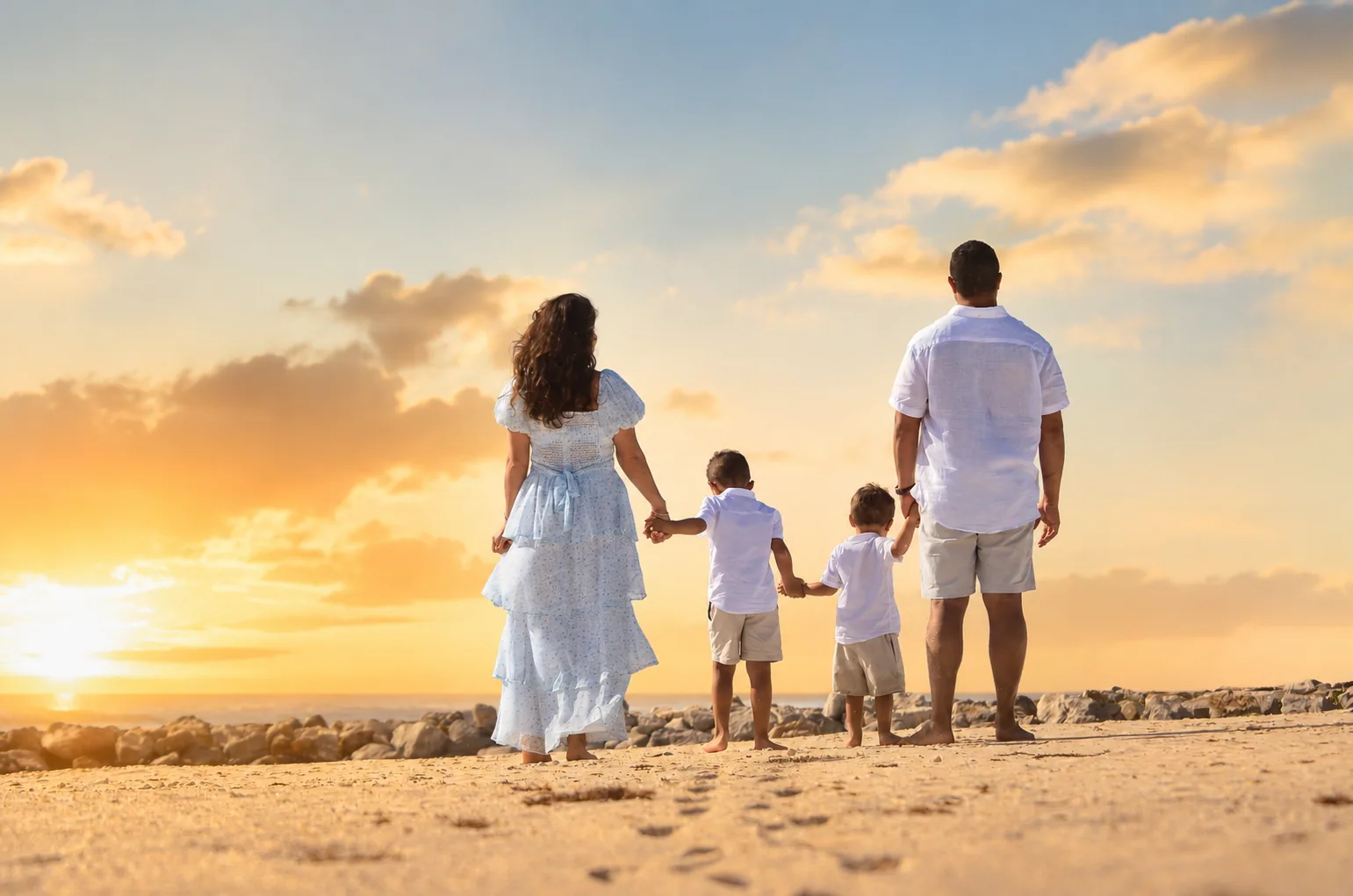 Familia caminando al atardecer frente al mar